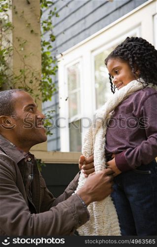 Father tying daughters scarf