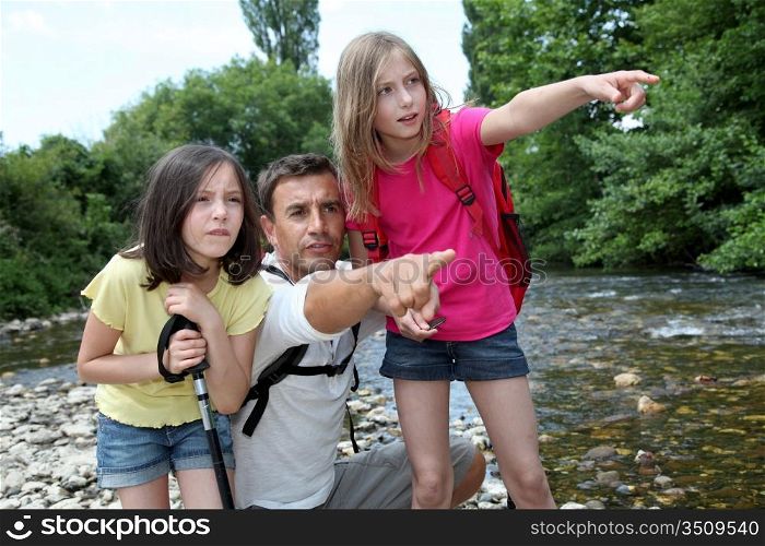 Father walking in river with kids