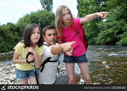Father walking in river with kids
