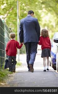Father Walking To School With Children On Way To Work
