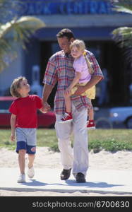 Father walking with his two daughters