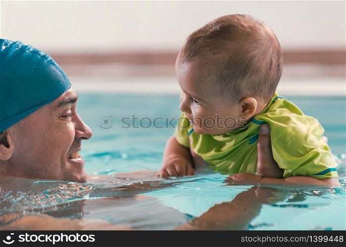Father with baby boy in the swimming pool