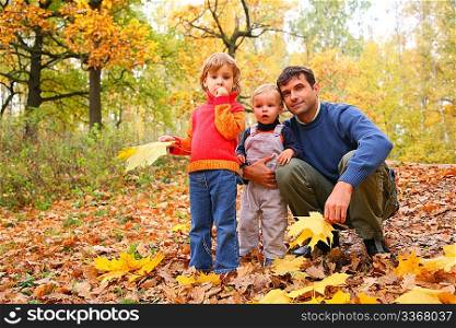 Father with children in autumn wood