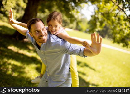 Father with cute little daughter having fun at the park