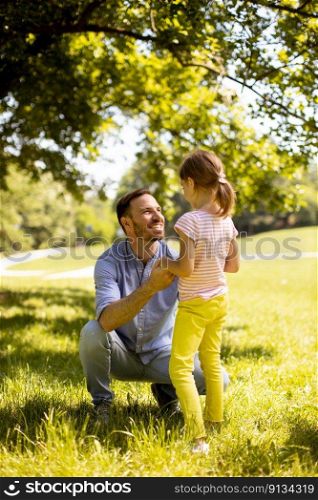 Father with cute little daughter having fun at the park
