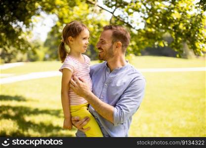 Father with cute little daughter having fun at the park