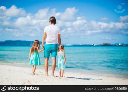 Father with kids on the beach enjoying summer. Family vacation. Happy beautiful family on a tropical beach vacation