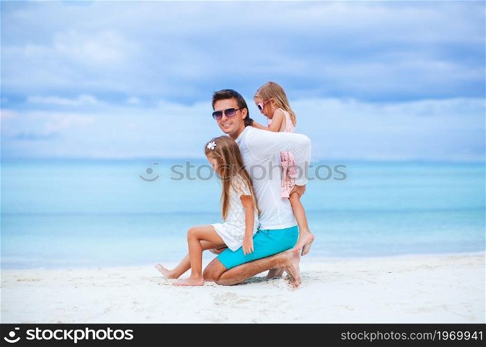Father with kids on the beach enjoying summer. Family vacation. Happy beautiful family on a tropical beach vacation