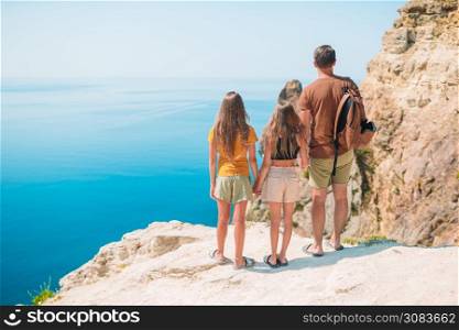 Father with kids on the beach enjoying summer. Family vacation in mountains. Happy beautiful family on a tropical beach vacation