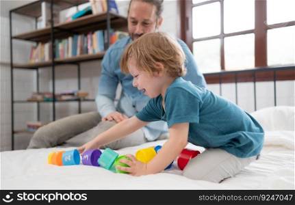 Father with little boy have fun playing with your new toys in the bedroom together. Toys that enhance children&rsquo;s thinking skills.