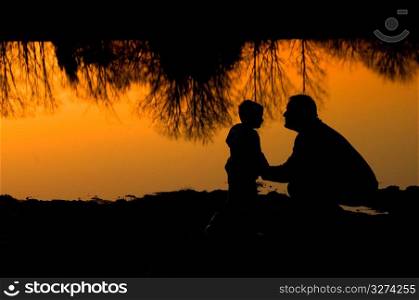 Father with son at dusk, side view
