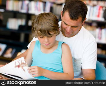 Father with son in library with books. Father with son in library