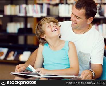 Father with son in library with books. Father with son in library