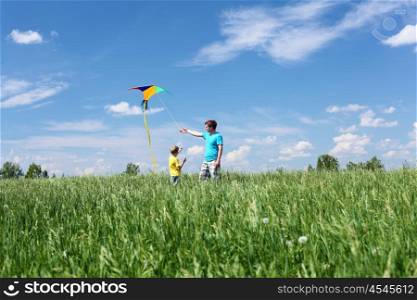 father with son in summer playing with kite