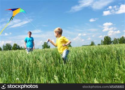 father with son in summer playing with kite