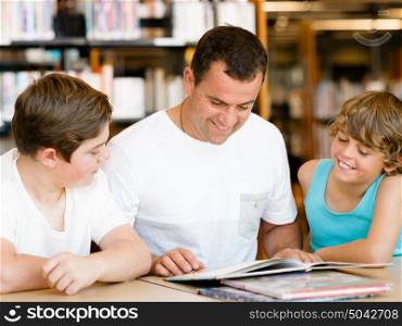 Father with sons in library with books. Father with sons in library