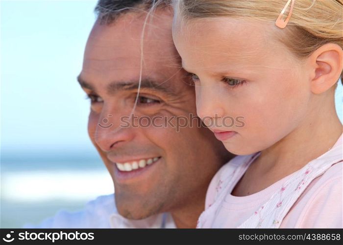 Father with young daughter by the ocean