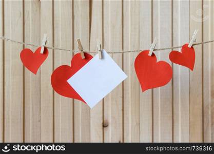 Fathers day. Card for message with red paper hearts hanging with clothespins over wooden board. Birthday. Valentines day. Fathers day. Card for message with paper hearts hanging with clothespins over light wooden board. Birthday. Valentines day. Wedding