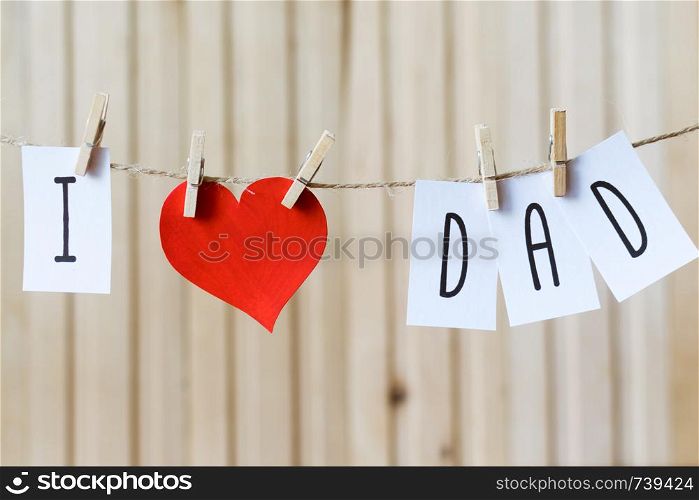 Fathers day concept. Message with paper hearts hanging with clothespins over light wooden board.. Fathers day concept. Message with paper hearts hanging with pins over light wooden board.