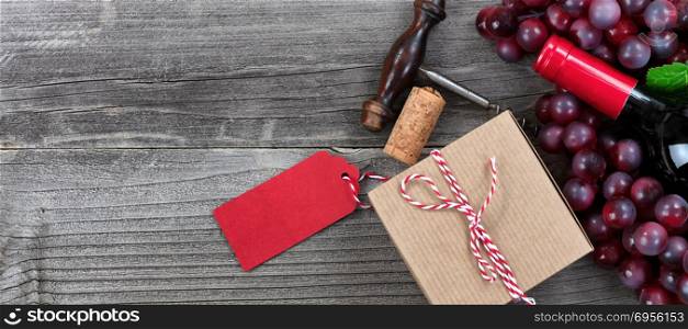 Fathers day gift box with red wine bottle and grapes on vintage wooden plank background