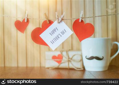 Fathers day message with red paper hearts hanging with clothespins over wooden board.. Fathers day message with paper hearts hanging with clothespins over wooden board