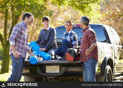 Fathers With Sons Unpacking Truck On Camping Holiday