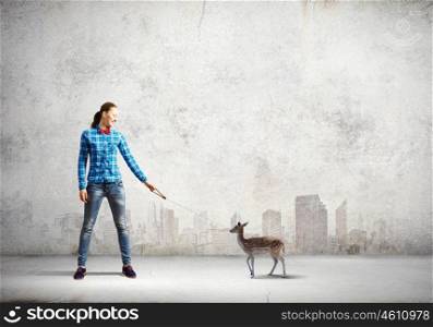 Fawn on lead. Young woman in casual holding fawn on lead