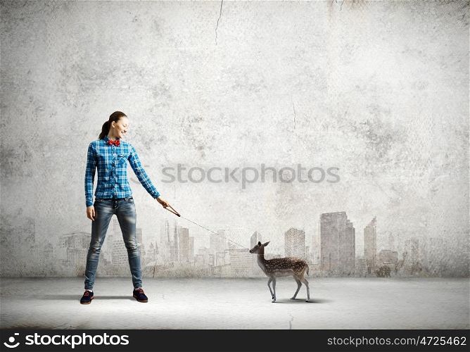 Fawn on lead. Young woman in casual holding fawn on lead
