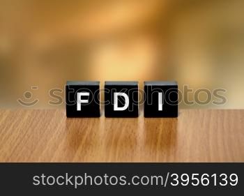 FDI or Foreign direct investment on black block with blurred background