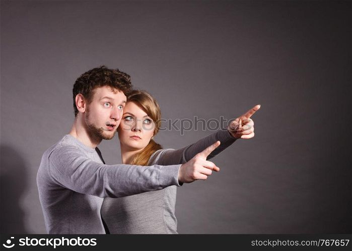 Fear and scare. Two young terrified scared people. Stressed woman and man showing to copy space. Couple afraid of bad things war.. Scared young couple showing copy space.