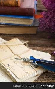 feather pen . old postage with books and blue feather pen