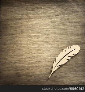 feather pen toy at plywood background. feather pen toy at wooden background surface