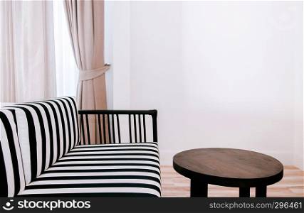 FEB 10, 2014 Chiang Mai, THAILAND - Black and white strips pattern armchair and old wood table contemporary style living room white wall with curtain and natural light