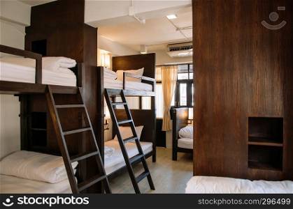 FEB 12, Chiang Mai, THAILAND - Hostel dormitory bunk beds arranged in room, backpacker hostel furnished with wooden dormitory style bunk beds and whit clean linens.