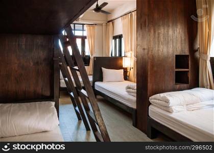 FEB 12, Chiang Mai, THAILAND - Hostel dormitory bunk beds arranged in room, backpacker hostel furnished with wooden dormitory style bunk beds and whit clean linens.