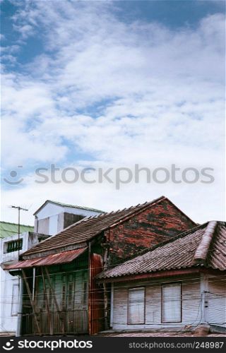 FEB 28, 2013 Songkhla, THAILAND - Old grunge wooden buildings with brick wall at Songkhla Nang Ngam street famous historic district in summer.