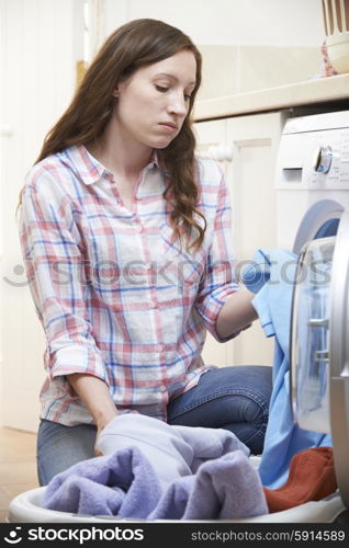 Fed Up Woman Doing Laundry At Home