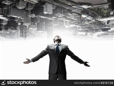 Feeling his power. Businessman with hands spread apart and city reflection in sky