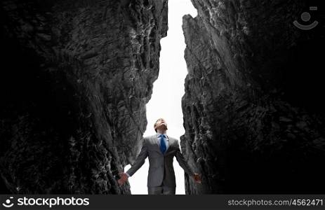Feeling his power. Businessman with hands spread apart on dark background