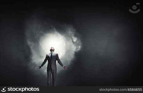 Feeling his power. Businessman with hands spread apart on dark background