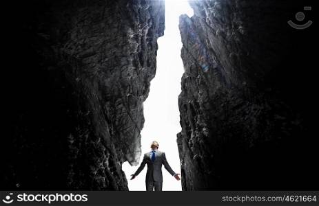 Feeling his power. Businessman with hands spread apart on dark background