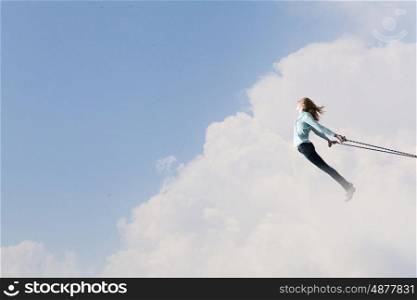 Feeling of freedom. Young girl with ropes on hands trying to fly