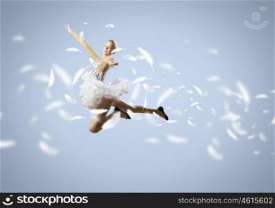 Feeling of lightness. Young pretty ballerina girl making jump in dance