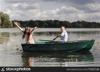 Feeling playful. Beautiful young couple enjoying romantic date while rowing a boat. Feeling playful. Beautiful young couple enjoying romantic date while rowing a boat. Happy to have each other.