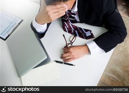 Feeling sick and tired. Frustrated middle aged businessman sitting at office desk