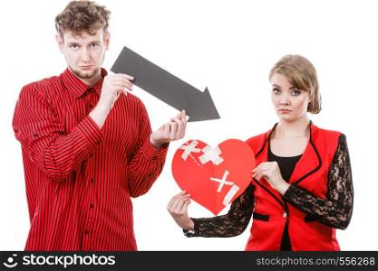 Feelings romance heartbreak making up reconcillation concept. Couple holding love symbols. Young man with woman showing pointer directed at broken fixed heart.. Couple holding love symbols.