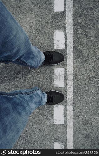 feet and sneakers on the ground in the street