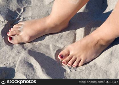 feet in the sand of the beach