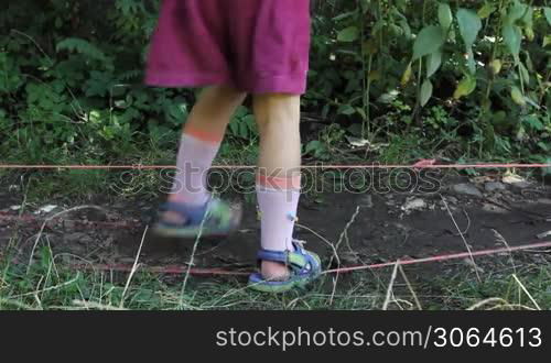 feet little girl jump through two stretched rubber bands, then go away