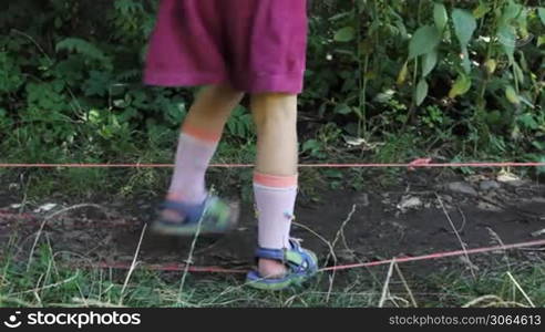 feet little girl jump through two stretched rubber bands, then go away